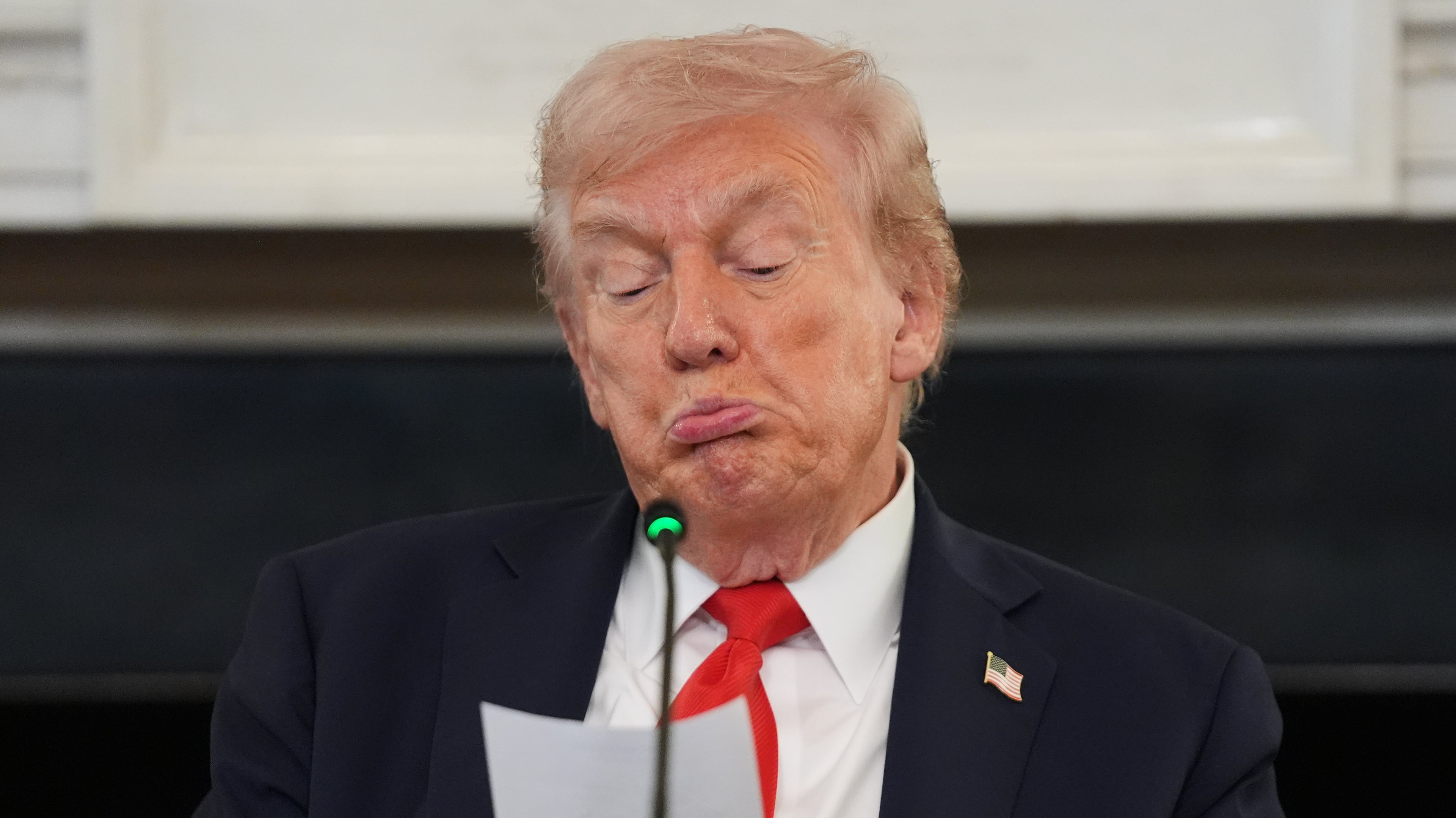 President Donald Trump reads a note handed to him by Secretary of State Marco Rubio during a roundtable meeting on antifa in the State Dining Room at the White House, Wednesday, Oct. 8, 2025, in Washington. (AP Photo/Evan Vucci)