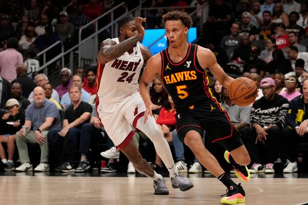 Atlanta Hawks guard Dyson Daniels (5) dribbles against Miami Heat forward Haywood Highsmith (24) in the first half of an NBA play-in tournament basketball game, Friday, April 18, 2025, in Atlanta. (AP Photo/Brynn Anderson)