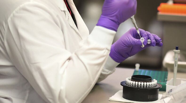 A lab technologist works in the extracting of RNA from test samples in a Mayo Clinic virology lab in Rochester, Minn. They’re working on a new coronavirus testing “moonshot” by partnering with the state and its flagship university to quickly boost the state’s capacity to 20,000 tests a day. A Georgia Tech professor says university labs can help ease the testing backlog. (David Joles/Star Tribune via AP)