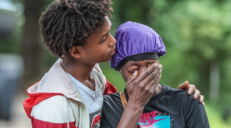 The victim's friend, Carnelo Brittain (left), and mother Stardrecous Brooks hug each other after the deadly shooting.