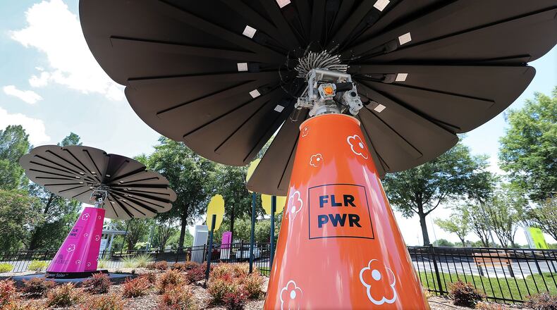A pair of the 16-foot tall smartflowers in the Solar garden at the Cobb EMC Corporate Campus are seen generating solar energy to the grid on Tuesday July 14, 2020 in Marietta.  Curtis Compton ccompton@ajc.com
