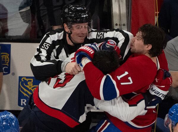 A referee (55) tries to separate Montreal Canadiens' Josh Anderson (17) and Washington Capitals' Tom Wilson, front left, as they fight following the second period of Game 3 of a first-round NHL hockey playoff series in Montreal, Friday, April 25, 2025. (Christinne Muschi/The Canadian Press via AP)