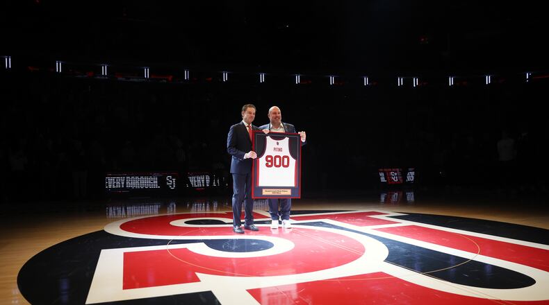 St. John's head coach Rick Pitino, left, is presented with a jersey by Ed Kull for his 900th win before an NCAA college basketball game against Butler, Wednesday, Jan. 28, 2026, in New York. (AP Photo/Heather Khalifa)