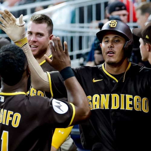 San Diego Padres' Manny Machado is greeted in the dugout after hitting a solo home run against the Atlanta Braves during the sixth inning of a baseball game, Tuesday, July 21, 2026, in Atlanta. (AP Photo/Erik S. Lesser)