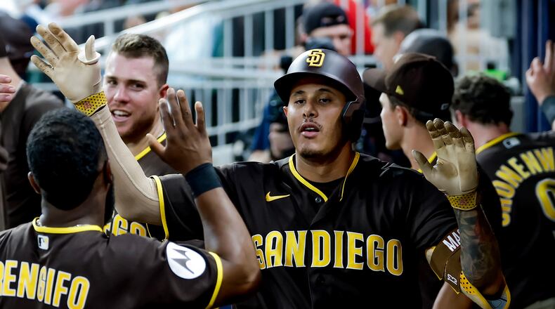 San Diego Padres' Manny Machado is greeted in the dugout after hitting a solo home run against the Atlanta Braves during the sixth inning of a baseball game, Tuesday, July 21, 2026, in Atlanta. (AP Photo/Erik S. Lesser)