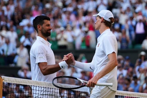 Jannik Sinner of Italy and Novak Djorkovic of Serbia shake hands after the men's semifinal singles match at the Wimbledon Tennis Championships in London, Friday, July 11, 2025.(AP Photo/Joanna Chan)