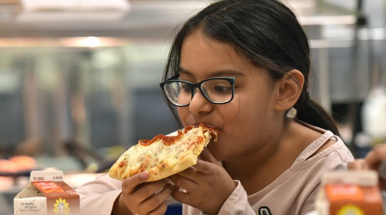 Angelic Ventura, 8, eats a slice of pizza with whole wheat crust for her lunch at Corley Elementary School on Wednesday, Dec. 12, 2018. Agriculture Secretary Sonny Perdue recently announced final rule school-meal guidelines designed to increase local flexibility in implementing nutrition standards for milk, whole grains and sodium. HYOSUB SHIN / HSHIN@AJC.COM