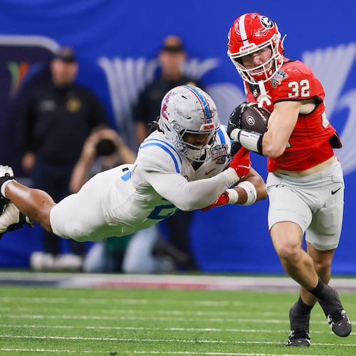 Georgia running back Cash Jones (right) — pictured running for a first down against Ole Miss in the College Football Playoff in January — did a little bit of everything for the Bulldogs after beginning his UGA career as a walk-on. (Jason Getz/AJC)