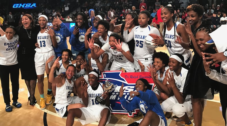 The McEachern Lady Indians pose with the AAAAAAA title trophy after beating Norcross for their fourth consecutive championship.
