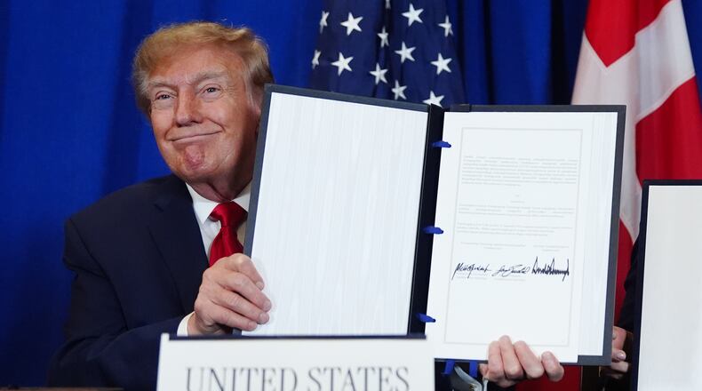 President Donald Trump holds up the document after signing a security agreement with Denmark's Prime Minister Mette Frederiksen and Greenland's Prime Minister Jens-Frederik Nielsen during the United Nations General Assembly, Tuesday, Sept. 22, 2026, at the UN headquarters. (AP Photo/Julia Demaree Nikhinson)