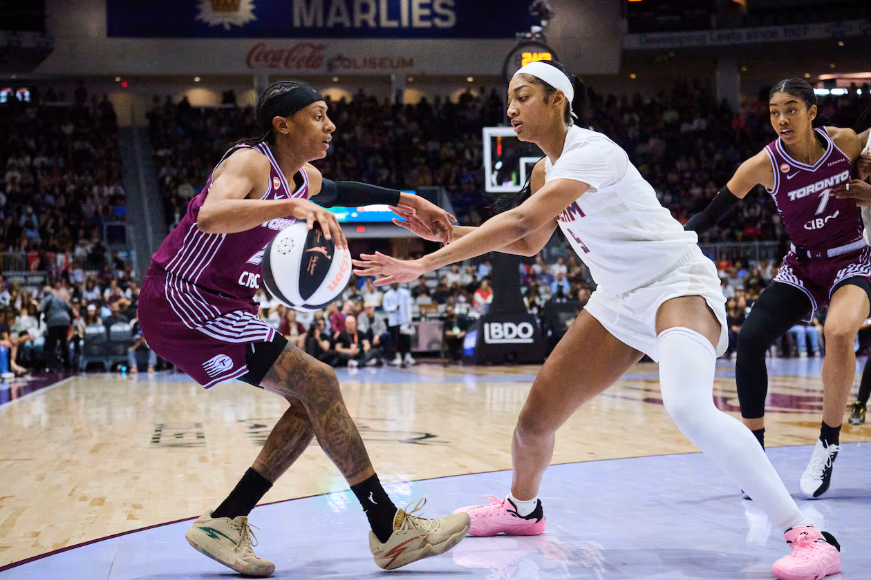 Toronto Tempo's Brittney Sykes, left, keeps the ball from Atlanta Dream's Angel Reese, second from left, during the first half of a WNBA basketball game in Toronto, Sunday, June 14, 2026. (Sammy Kogan/The Canadian Press via AP)