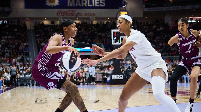Toronto Tempo's Brittney Sykes, left, keeps the ball from Atlanta Dream's Angel Reese, second from left, during the first half of a WNBA basketball game in Toronto, Sunday, June 14, 2026. (Sammy Kogan/The Canadian Press via AP)