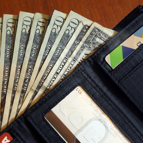 FILE - Cash is fanned out from a wallet in North Andover, Mass, June 15, 2018. (AP Photo/Elise Amendola, File)