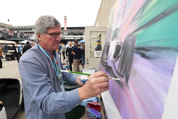 Artist William Patterson paints in Gasoline Alley before the start of the Indianapolis 500 auto race at Indianapolis Motor Speedway in Indianapolis, Sunday, May 25, 2025. (AP Photo/AJ Mast)
