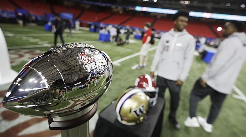 The Chick-fil-A Peach Bowl trophy stands on the field during media day at the Georgia Dome on Thursday. (Photo by David Goldman/AP)