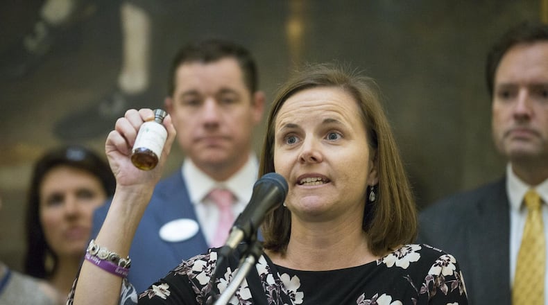 Shannon Cloud, the parent of a child who suffers from seizures, holds up a bottle of THC oil during a press conference in the rotunda of the Georgia State Capitol building in Atlanta on February 14, 2019. Cloud was surrounded by other families and lawmakers as they proposed a law that would grant the legalization of growing and distributing medical marijuana to registered patients. (ALYSSA POINTER/ALYSSA.POINTER@AJC.COM)