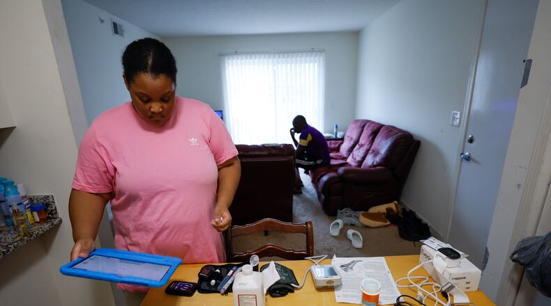 Asia Daniels, an Augusta University Medical Center patient, receives medical care without leaving the comfort of her home, through telemedicine. Here, she is preparing to take her vitals using equipment the hospital set up at her home, and she will send the results electronically to her nurses and doctors at the hospital. Tuesday, Nov. 21, 2023. (PHOTO by Miguel Martinez / miguel.martinezjimenez@ajc.com)
