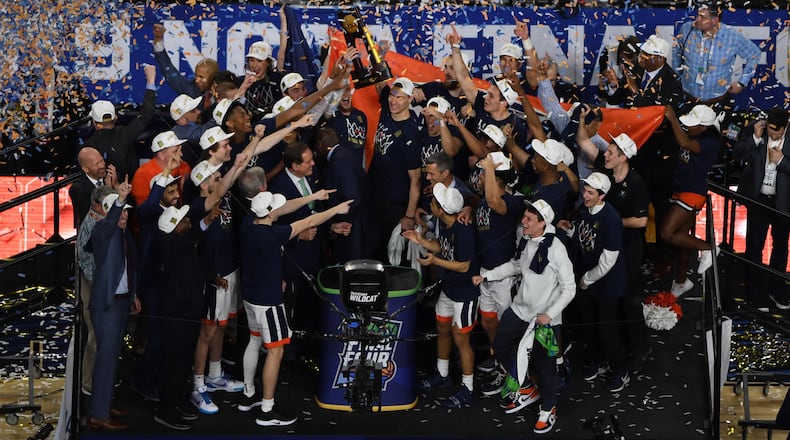 Virginia players celebrate with the trophy after defeating Texas Tech in the national championship game.