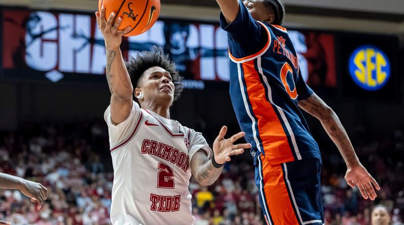 Alabama guard Aden Holloway (2) looks to shoot past Auburn guard Tahaad Pettiford (0) during the second half of an NCAA college basketball game Saturday, March 7, 2026, in Tuscaloosa, Ala. (AP Photo/Vasha Hunt)