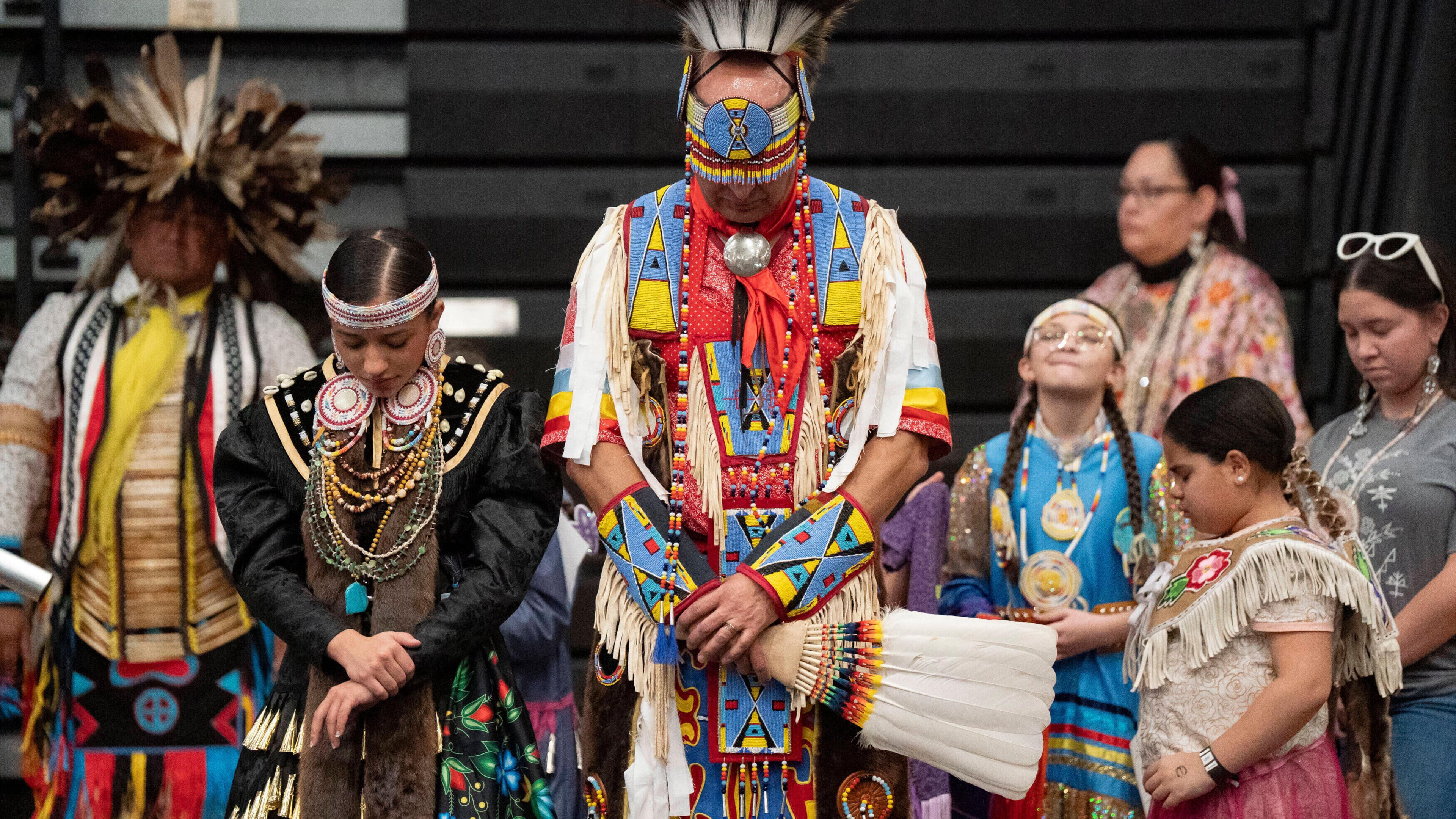 FILE - Members of the Lumbee Tribe bow their heads in prayer during the BraveNation Powwow and Gather at UNC Pembroke, March 22, 2025, in Pembroke, N.C. (AP Photo/Allison Joyce, file)