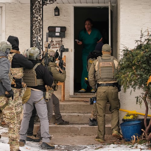 ADDS IDENTIFICATION: Teyana Gibson Brown, second from right, wife of Garrison Gibson, reacts after a federal immigration officer used a battering ram to break down a door before arresting Garrison Gibson, Sunday, Jan. 11, 2026, in Minneapolis. (AP Photo/John Locher)