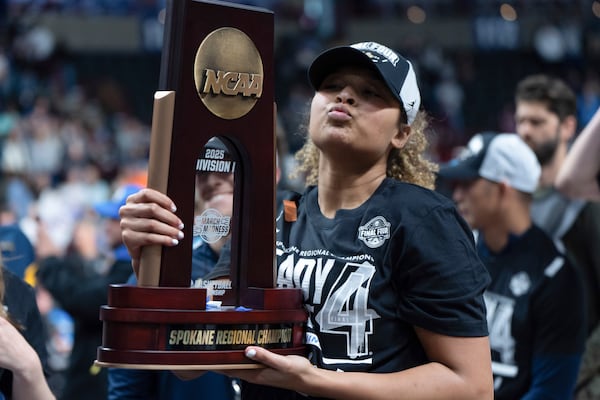 UCLA guard Avary Cain poses with the tropy after a game against LSU in the Elite Eight of the NCAA college basketball tournament, Sunday, March 30, 2025, in Spokane, Wash. (AP Photo/Jenny Kane)