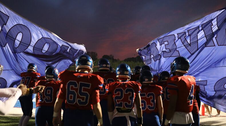 Riverwood players break through their banner before their game against Carver-Atlanta Oct. 18, 2019, at Riverwood High School in Sandy Springs.