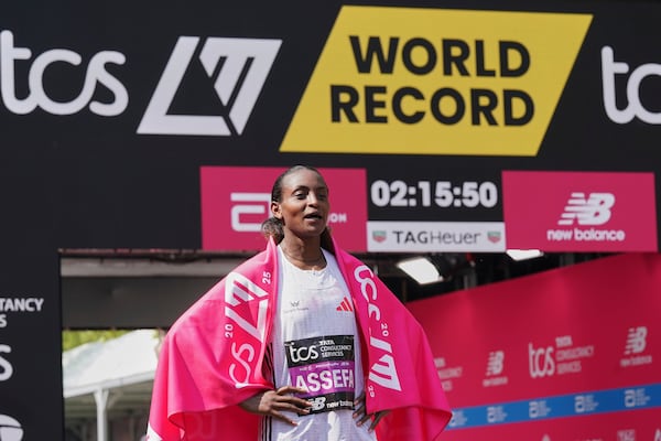 Tigst Assefa of Ethiopia poses for the cameras after setting a new women's only world record time and winning the women's race at the London Marathon, Sunday, April 27, 2025. (AP Photo/Alberto Pezzali)
