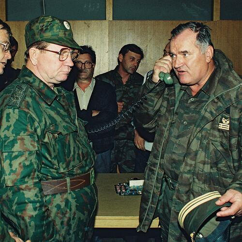FILE - Bosnian Serb General Ratko Mladic, right, talks on the phone next to Russian Army General Vladimir Zurbenko, center, during the visit of a Russian Army delegation to the Bosnian town of Banja Luka in Oct. 1995. (AP Photo/Radivoje Pavicic, File)