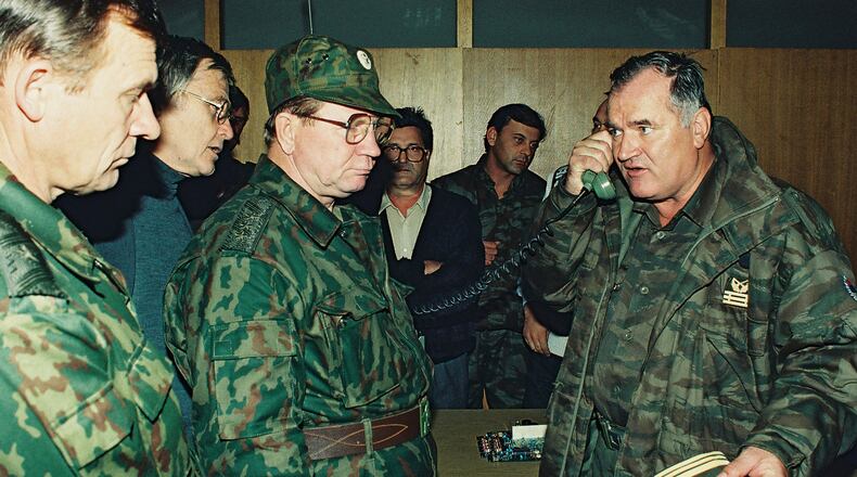 FILE - Bosnian Serb General Ratko Mladic, right, talks on the phone next to Russian Army General Vladimir Zurbenko, center, during the visit of a Russian Army delegation to the Bosnian town of Banja Luka in Oct. 1995. (AP Photo/Radivoje Pavicic, File)