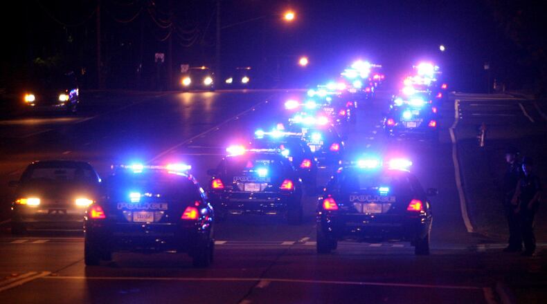 Sandy Springs police cars, travel south on Roswell Road during a ceremonial changing of the guard at midnight following a reception launching Sandy Springs’ new police department June 30, 2006. (Brant Sanderlin/AJC staff)