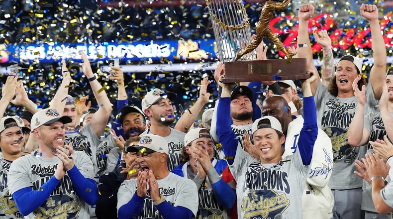 Los Angeles Dodgers pitcher Yoshinobu Yamamoto, center right, lifts the World Series MVP trophy as the Dodgers celebrate after defeating the Toronto Blue Jays in Game 7 of baseball's World Series, Sunday, Nov. 2, 2025, in Toronto. (Nathan Denette/The Canadian Press via AP)