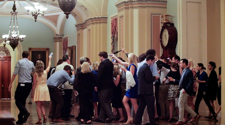 Members of media surround a Republican lawmaker through the hallways on Capitol Hill in Washington Thursday, July 13, 2017. Senate Majority Leader Mitch McConnell of Ky., rolled out the GOP's revised health care bill, pushing toward a showdown vote next week with opposition within the Republican ranks. (AP Photo/Pablo Martinez Monsivais)