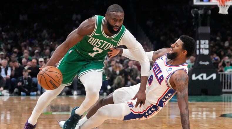 FILE - Boston Celtics guard Jaylen Brown (7) drives to the basket against Philadelphia 76ers forward Paul George (8) during the first half of Game 2 of a first-round NBA playoffs basketball series, April 21, 2026, in Boston. (AP Photo/Charles Krupa, File)