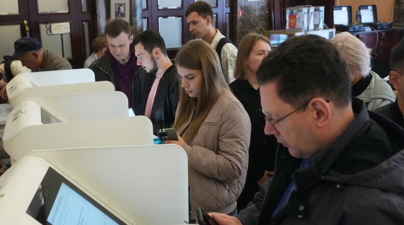 Voters use an electronic voting system in the parliamentary election in Moscow, Friday, Sept. 18, 2026. (AP Photo/Pavel Bednyakov)