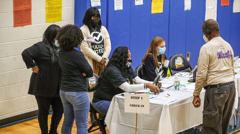 Poll workers outnumbered voters Tuesday morning at the Dunbar Neighborhood Center in Atlanta. Tuesday marked the first major election for the state's new voting law, Senate Bill 202, and that placed new requirements for reporting on county election offices. (John Spink / John.Spink@ajc.com)