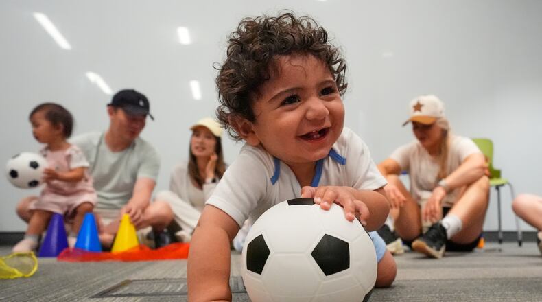 Ten-month-old Zain Fawaz plays with a soccer ball at a program introducing toddlers to the sport ahead of the World Cup soccer tournament Thursday, June 4, 2026, in Lenexa, Kan. (AP Photo/Charlie Riedel)
