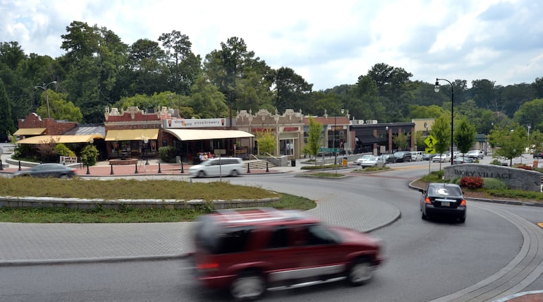 Cars drive through a traffic circle, shops and restaurants in Emory Village near an entrance to Emory University in Atlanta in this 2014 file photo. HYOSUB SHIN / HSHIN@AJC.COM
