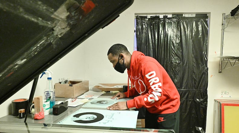 Reggie Boone works on color separation at Clothez Minded Custom Apparel in Norcross on Friday, March 19, 2021. Boone is currently a full-time graphic designer but started as an intern through Vowe, which sought a PPP federal relief loan to survive the pandemic. (Hyosub Shin / Hyosub.Shin@ajc.com)