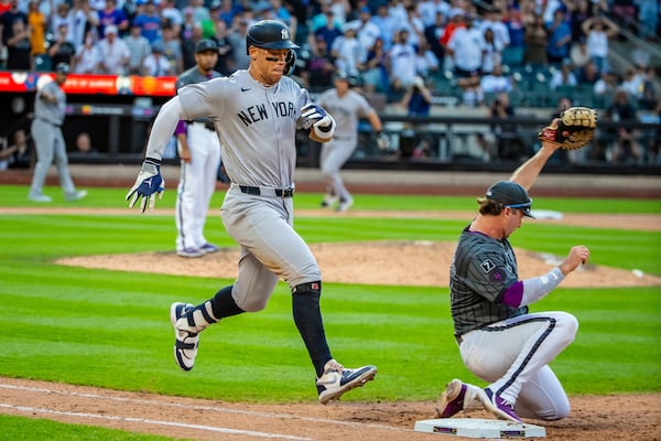 New York Yankees' Aaron Judge, left, is out at first base during the ninth inning of a baseball game against the New York Mets, Saturday, July 5, 2025, in New York. (AP Photo/Angelina Katsanis)