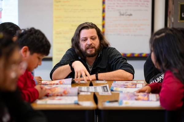 Vickery Mill fourth grade teacher Dylan Townsenger helps his class read and comprehend a story called “Sadie's Game” during an English/Language Arts class on Thursday, March 5, 2026. (Ben Hendren for the AJC)