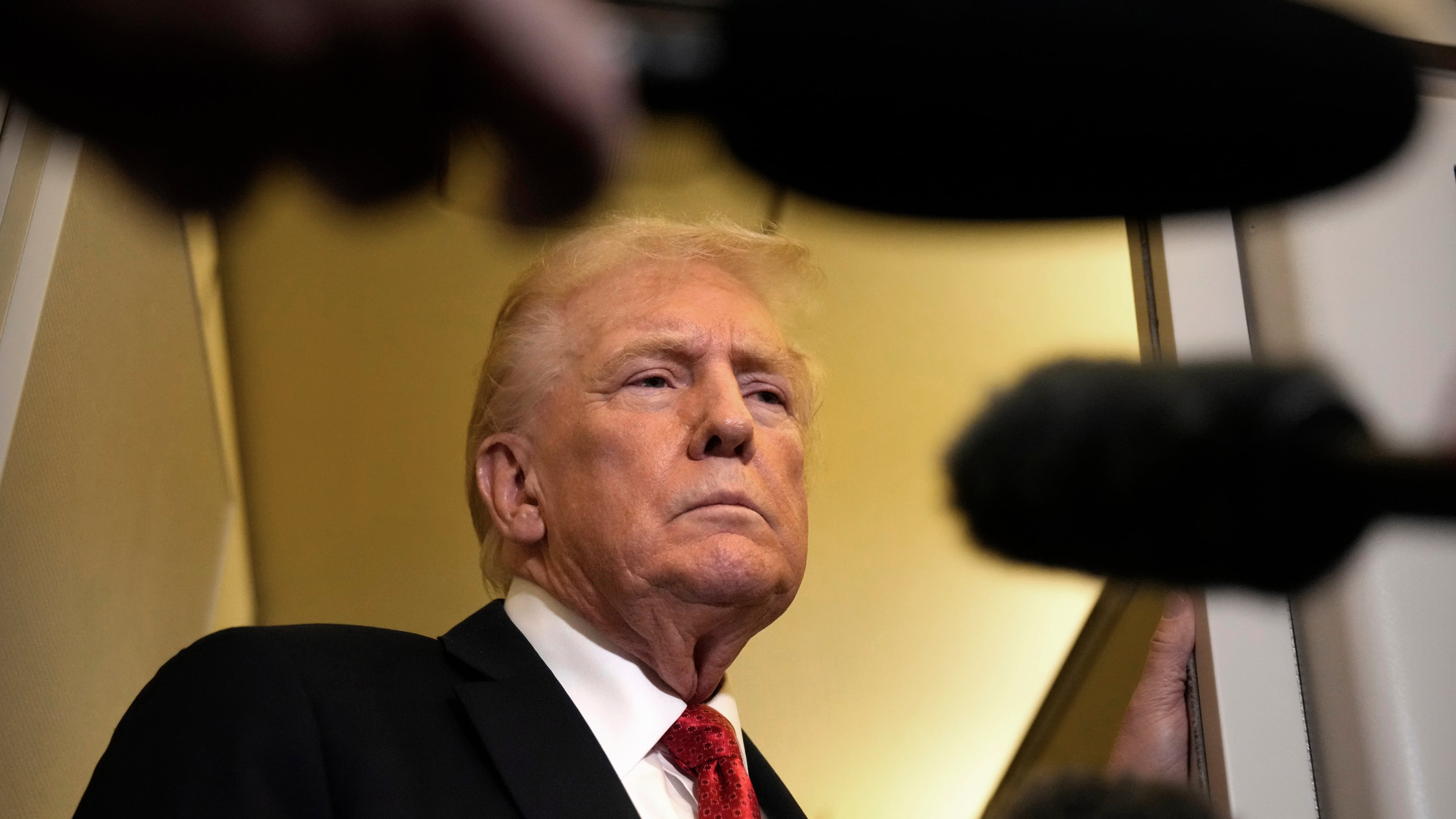 President Donald Trump speaks to reporters aboard Air Force One, Sunday, Oct. 19, 2025, en route to Joint Base Andrews, Md., as he returns from a trip to Florida. (AP Photo/Mark Schiefelbein)