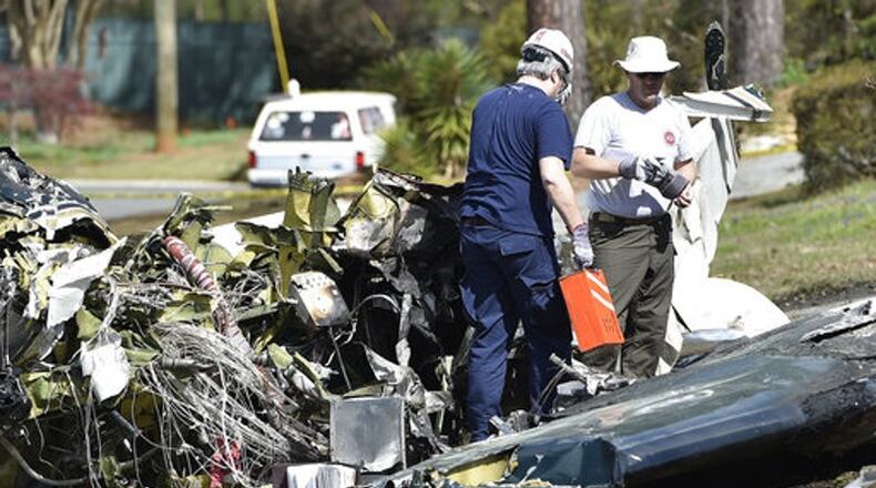 Officials with the NTSB and FAA remove a black box from the crashed Cessna Citation I in Cobb County. (Credit: Associated Press)