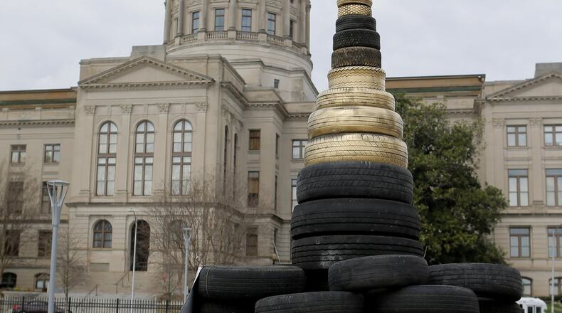 Residents from across the state held a rally across from the Georgia Capitol, using scrap tires to build a replica of the statehouse in Liberty Plaza that they dubbed the “Scrapitol.” They were advocating for legislation forcing the state to stop raiding trust funds for things such as tire dump and hazardous waste cleanups and driver’s education programs. Lawmakers are considering a proposed constitutional amendment that would allow legislators to safeguard such fee-funded programs. BOB ANDRES /BANDRES@AJC.COM
