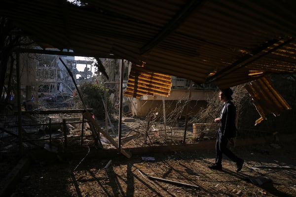 A person looks out at a destroyed residential building that was hit by a missile fired from Iran, in Ramat Gan, near Tel Aviv, Israel, on Saturday, June 14, 2025. (AP Photo/Ariel Schalit)