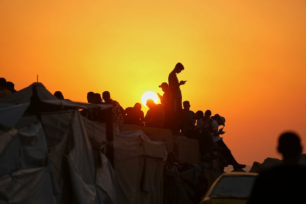 Palestinians spend time at the seafront at sunset in the Gaza City port, Friday, June 13, 2025. (AP Photo/Jehad Alshrafi)