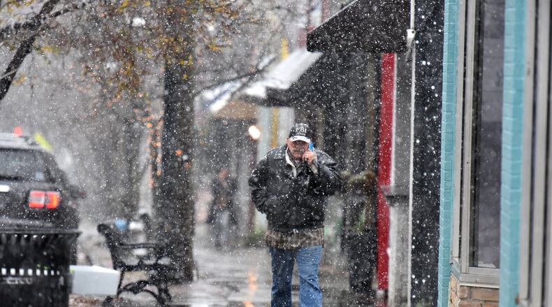 A pedestrian makes his way as a wintry mix of sleet and snow is falling in East Atlanta Village. HYOSUB SHIN / HSHIN@AJC.COM