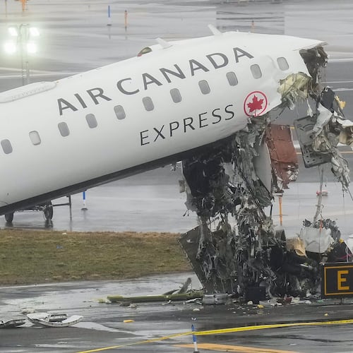 FILE - Officials investigate the site, Monday, March 23, 2026, where an Air Canada jet came to rest after colliding with a Port Authority firetruck at LaGuardia Airport, shortly after landing Sunday night in New York. (AP Photo/Seth Wenig, file)