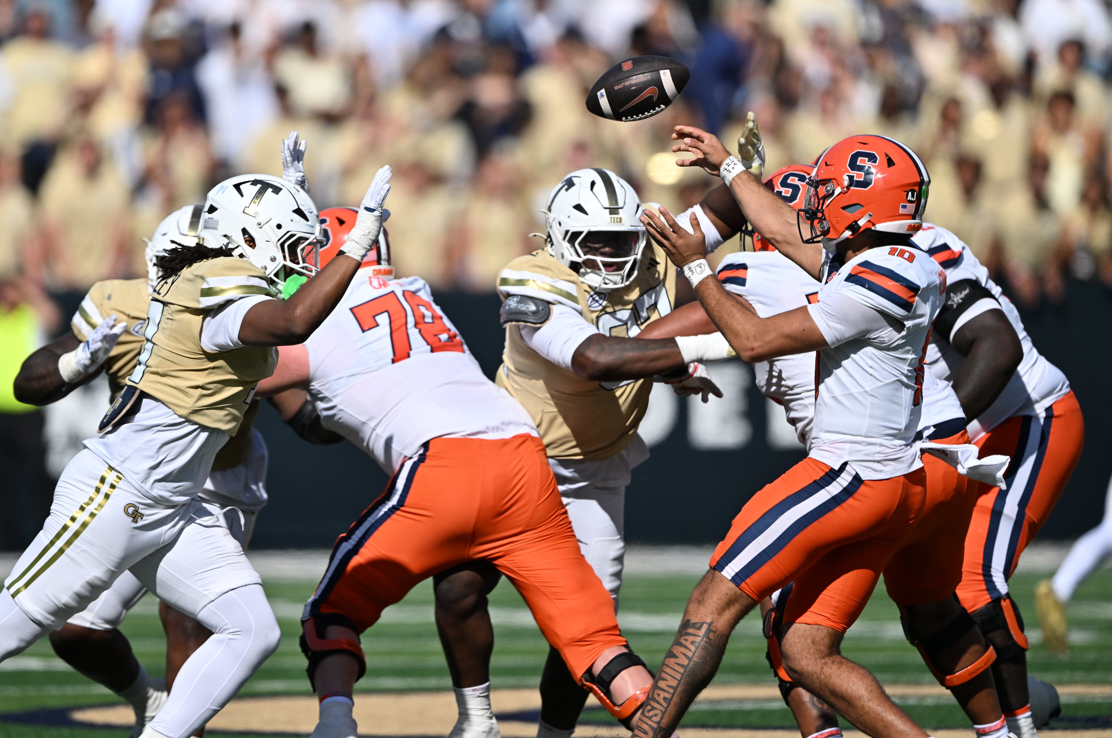 Syracuse quarterback Rickie Collins (center) gets off a pass under pressure from Georgia Tech defense players during the second half in an NCAA college football game at Bobby Dodd Stadium, Saturday, Oct. 25, 2025 in Atlanta. Georgia Tech won 41-16 over Syracuse. The Yellow Jackets are 8-0 for the first time since 1966 and 5-0 in the ACC for the first time ever. (Hyosub Shin/AJC)