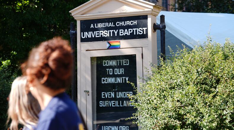 People walk by a sign outside University Baptist Church, Friday, Sept. 4, 2026, in Minneapolis. (AP Photo/Ellen Schmidt)